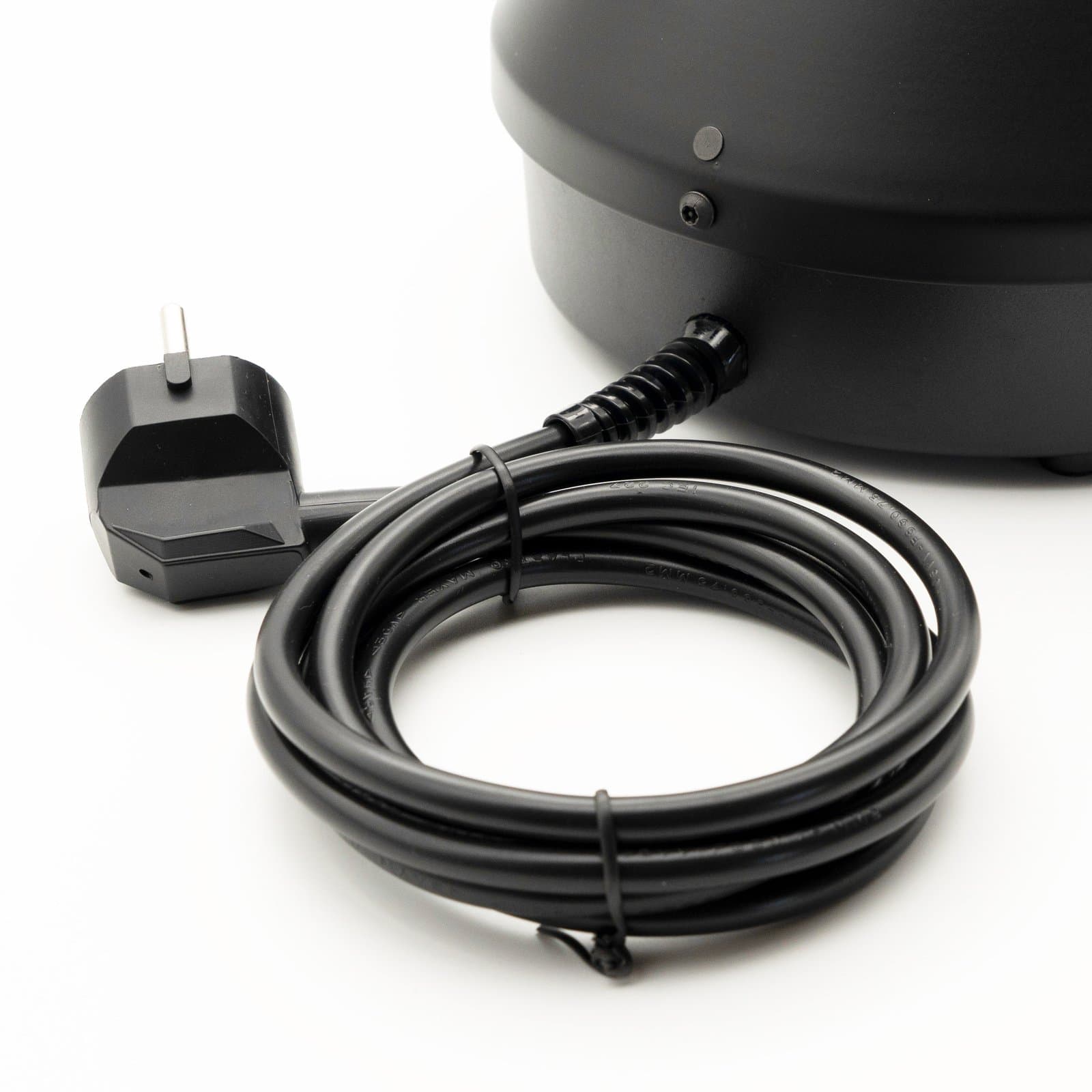 Coiled black power cord and plug beside Volcano base