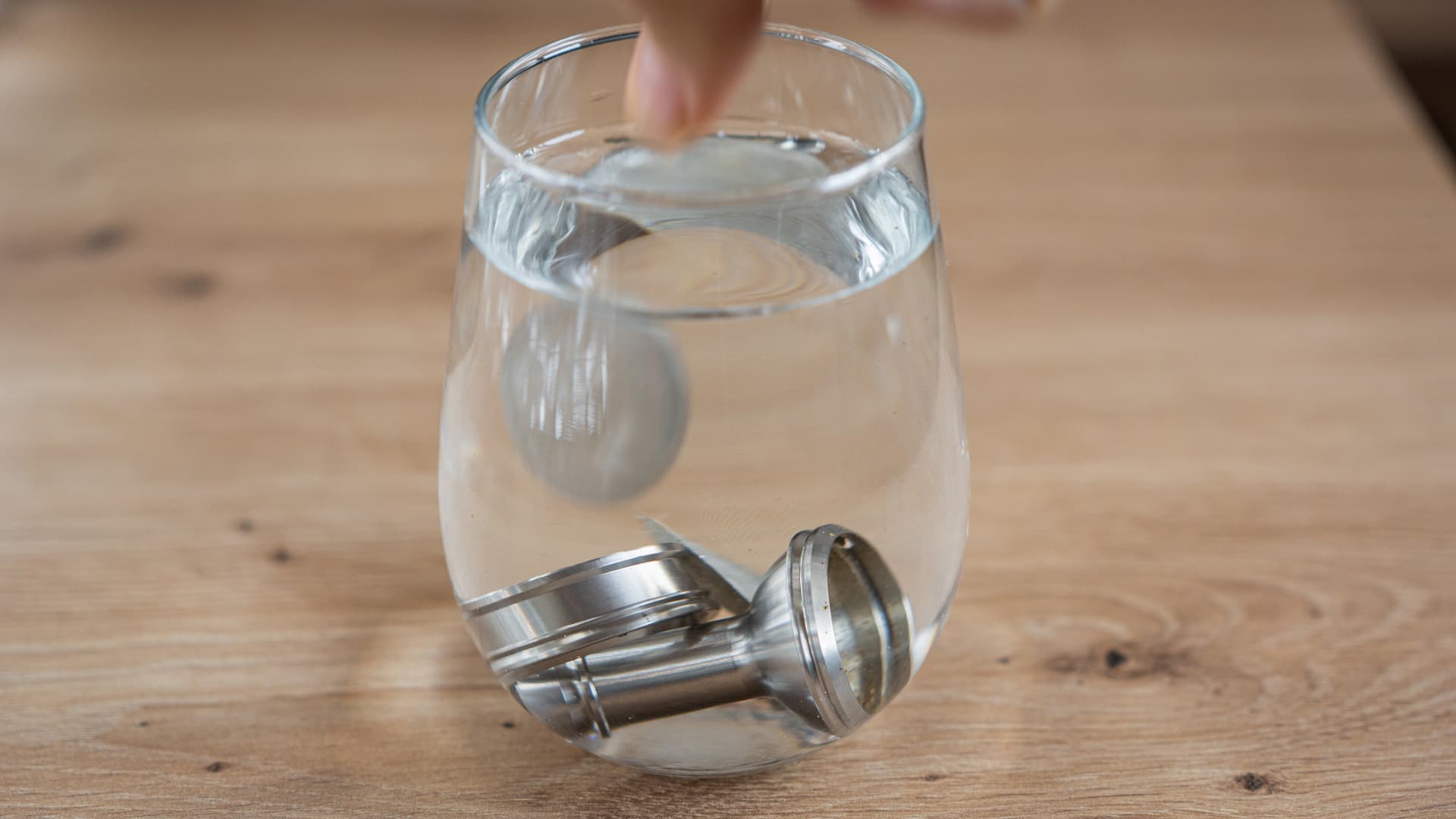 Teile der Füllkammer des Volcano Classic weichen in einem Glas mit Flüssigkeit ein