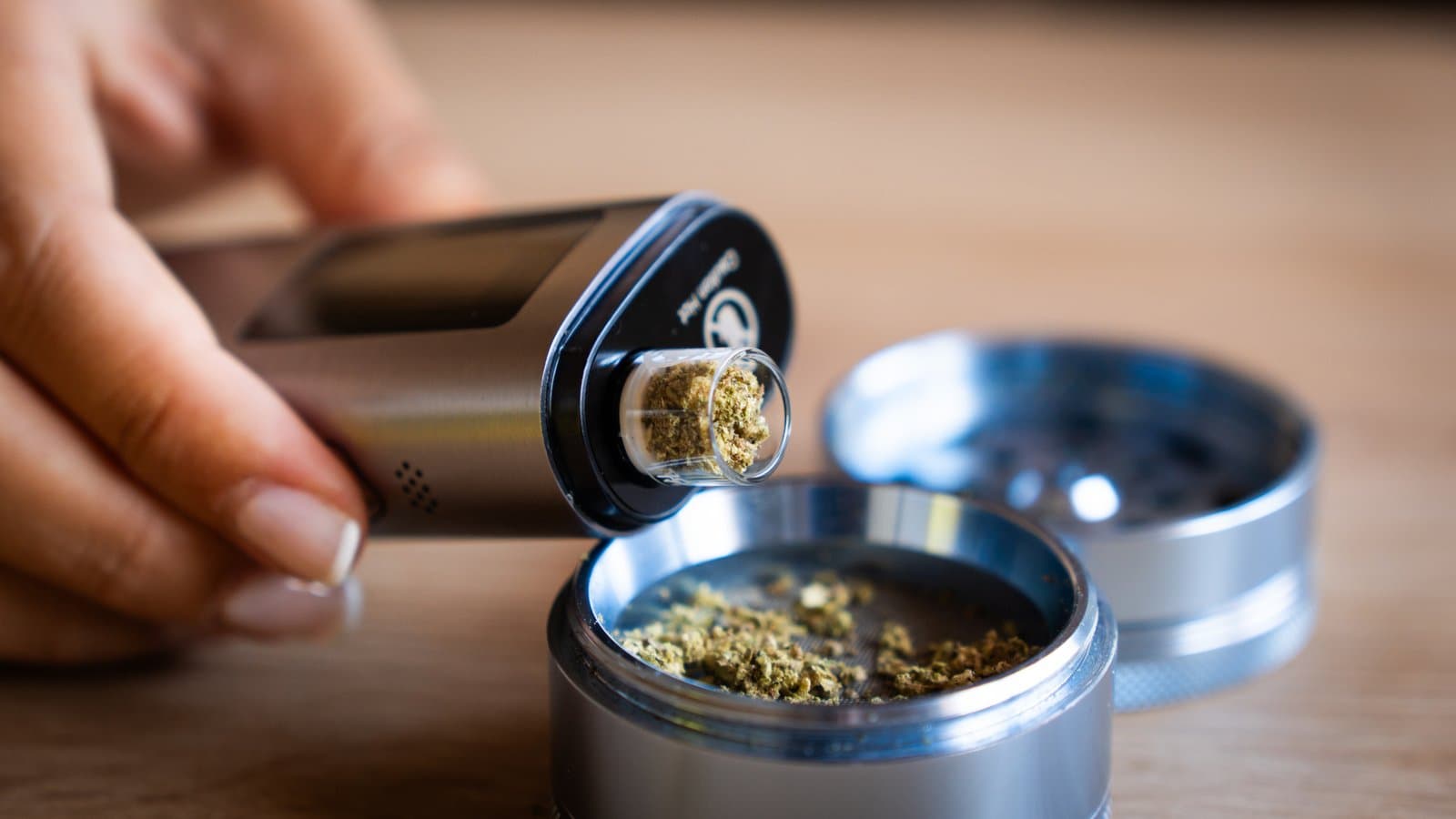 XLUX Roffu kopfüber gehalten, die Glaskammer taucht direkt in einen Metall-Grinder, um gemahlenes Cannabis aufzunehmen