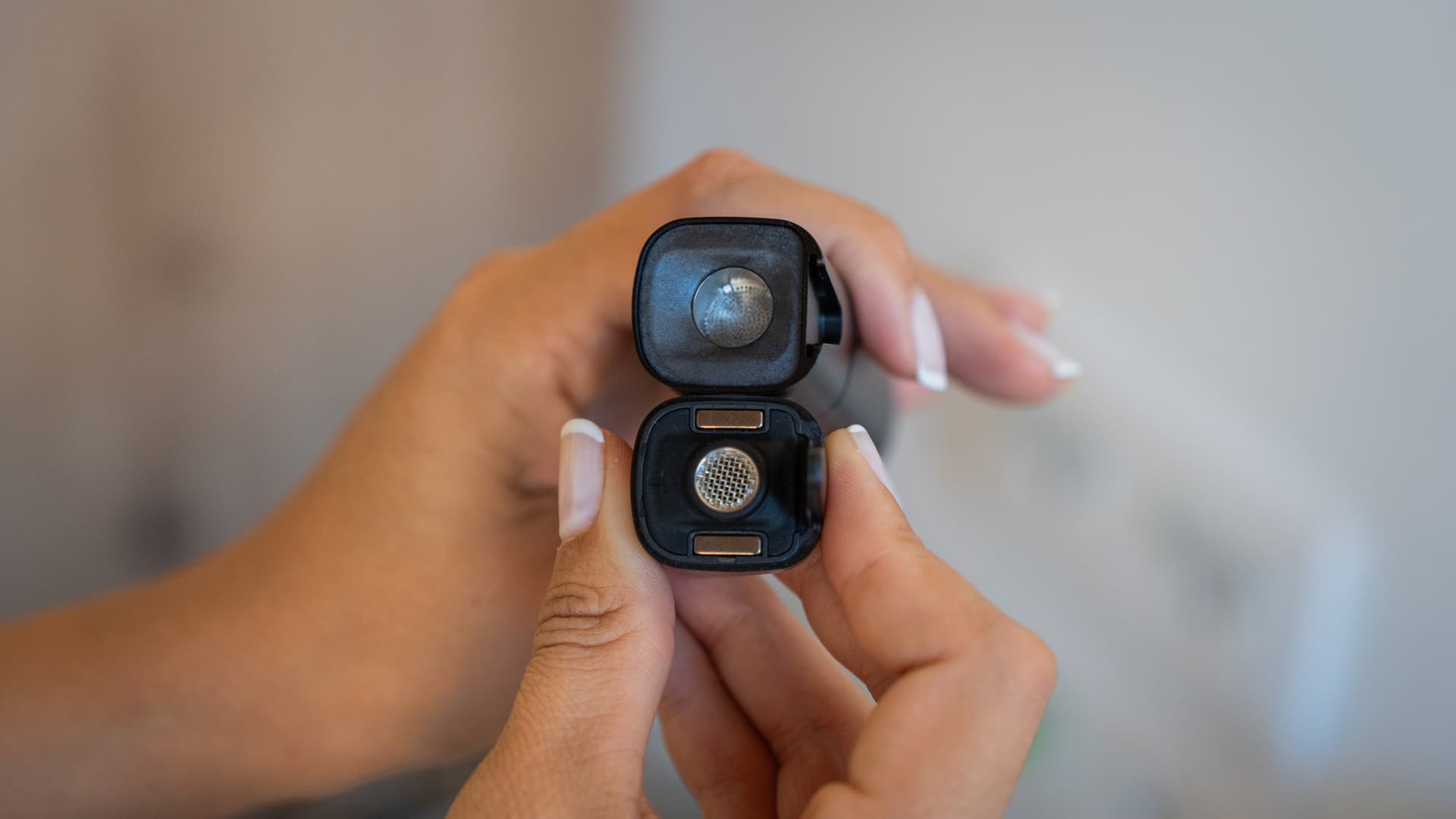 Hands holding the detached XMax V3 Pro mouthpiece above the oven screen