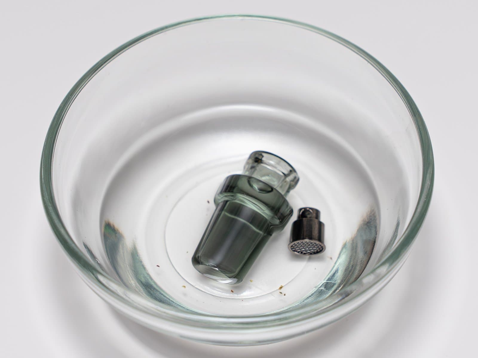 Abgenommenes Mundstück und Filterteile des XMax V4 Pro in einer Glasschale