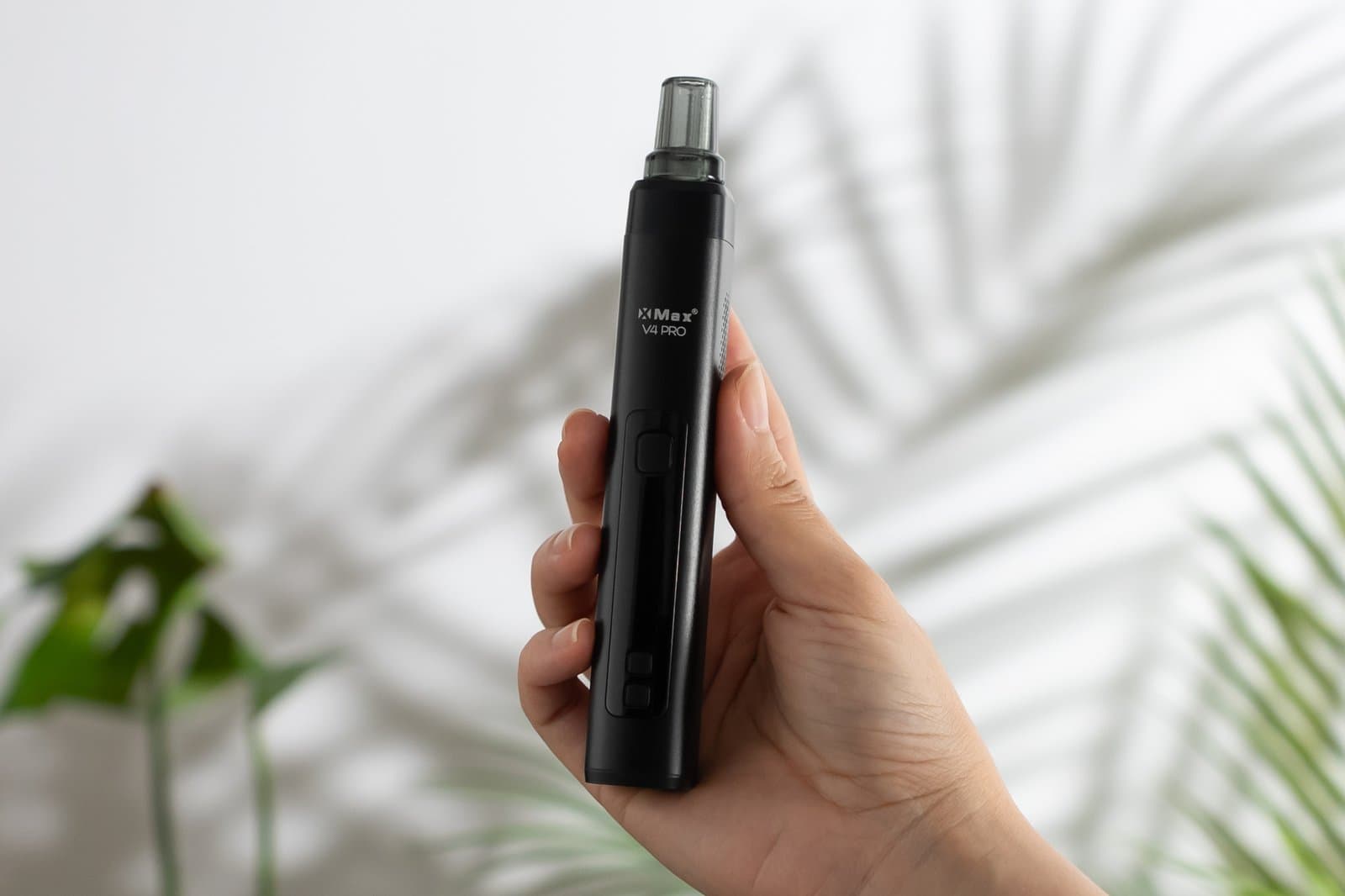 XMax V4 Pro in einer Hand gehalten, mit kompaktem Gehäuse aus anodisiertem Aluminium und Mundstück aus Borosilikatglas