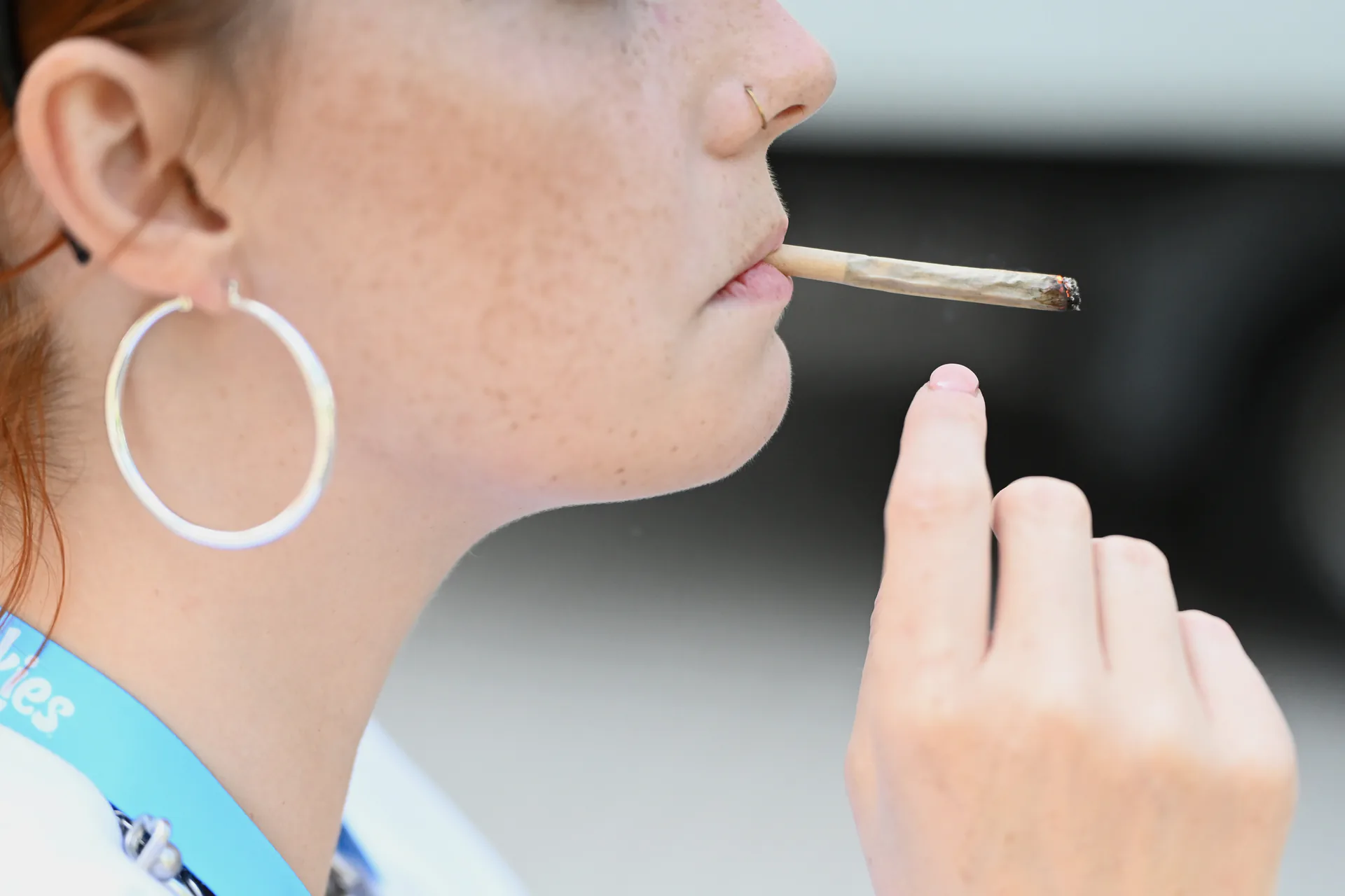 A woman smokes a joint on the fringes of the Mary Jane cannabis fair in Berlin, Thursday, June 19, 2025.