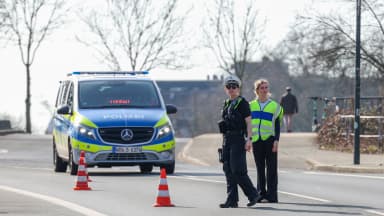 Police officers stand with their car on the side of the road at a traffic stop in Duesseldorf, North Rhine-Westphalia, Germany, on Thursday, Feb. 26, 2026. | Christoph Reichwein/dpa/picture-alliance/Newscom