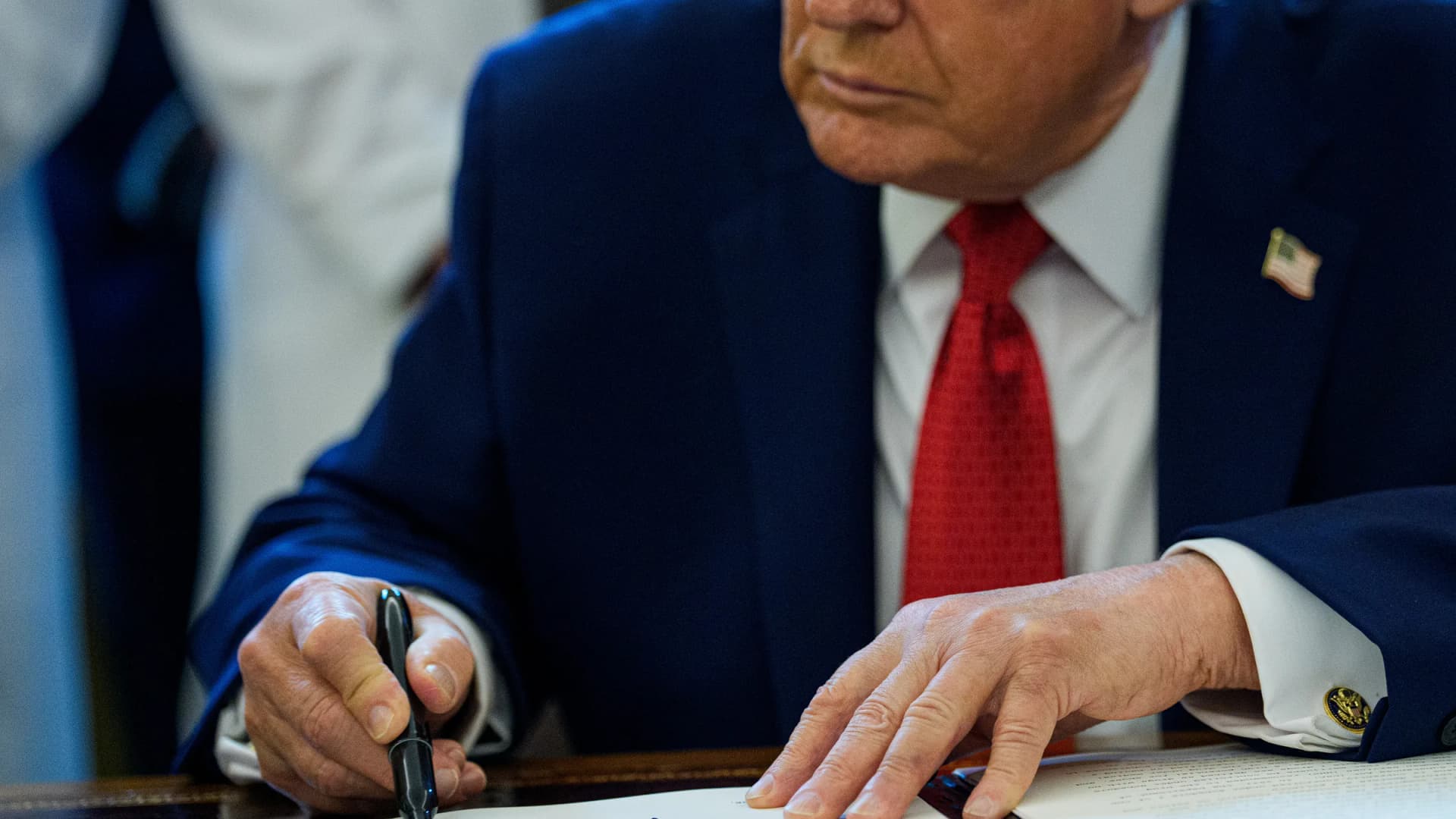 United States President Donald J. Trump signs an executive order in the Oval Office of the White House in Washington, D.C., on Thursday, Dec. 18, 2025. | Aaron Schwartz/UPI/Newscom