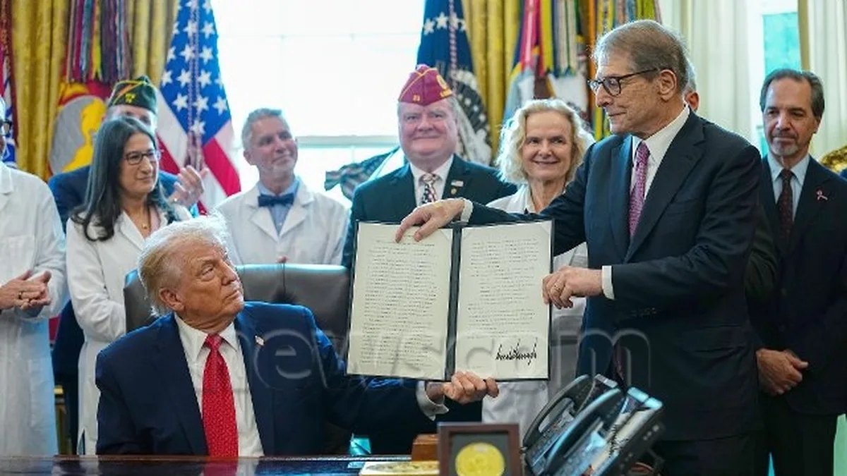 United States President Donald J. Trump displays a document after signing an executive order to reschedule marijuana from a Schedule I to a Schedule III controlled substance in the Oval Office of the White House in Washington, Thursday, Dec. 18, 2025.