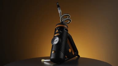 Storz & Bickel Plenty vaporizer with stainless steel cooling coil photographed against a warm amber gradient. | VapeExperts