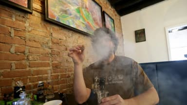Ray Bungay, co-owner of Philadelphia Temple of Hemp and Cannabis, vapes hemp flower rosin from a dab rig in his shop in Philadelphia on March 13, 2019. Dabbing fans celebrate the ritual each July 10, known as 710. (David Maialetti/The Philadelphia Inquirer/TNS/Newscom)