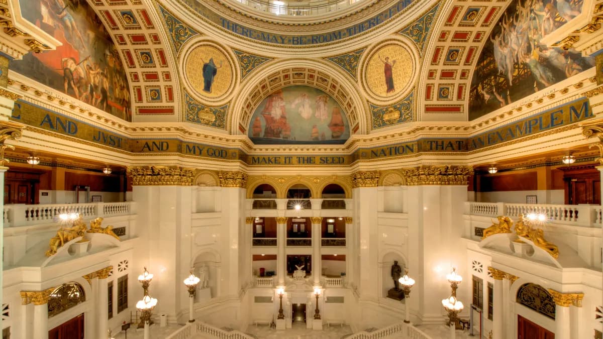 Interior of the Pennsylvania State Capitol rotunda with painted dome, gold ornamentation and white marble staircases. | Bestbudbrian/Wikimedia Commons (CC BY-SA 3.0)
