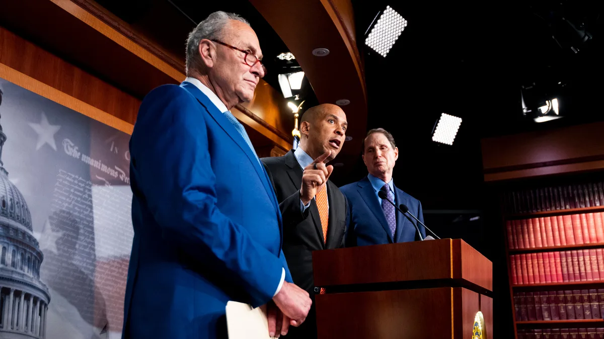 Sen. Cory Booker, D-N.J., flanked by Senate Majority Leader Chuck Schumer, D-N.Y., and Sen. Ron Wyden, D-Ore., speaks at a Capitol news conference introducing the Cannabis Administration and Opportunity Act in July 2021. | Bill Clark/CQ Roll Call/Newscom