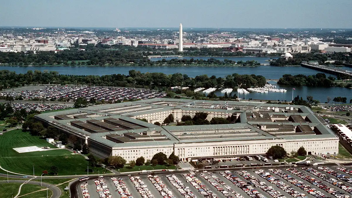 Aerial view of the Pentagon building surrounded by parking lots, with the Potomac River and Washington, D.C. skyline in the background. | 'DoD photo by Master Sgt. Ken Hammond, U.S. Air Force.'/Wikimedia Commons (Public domain)