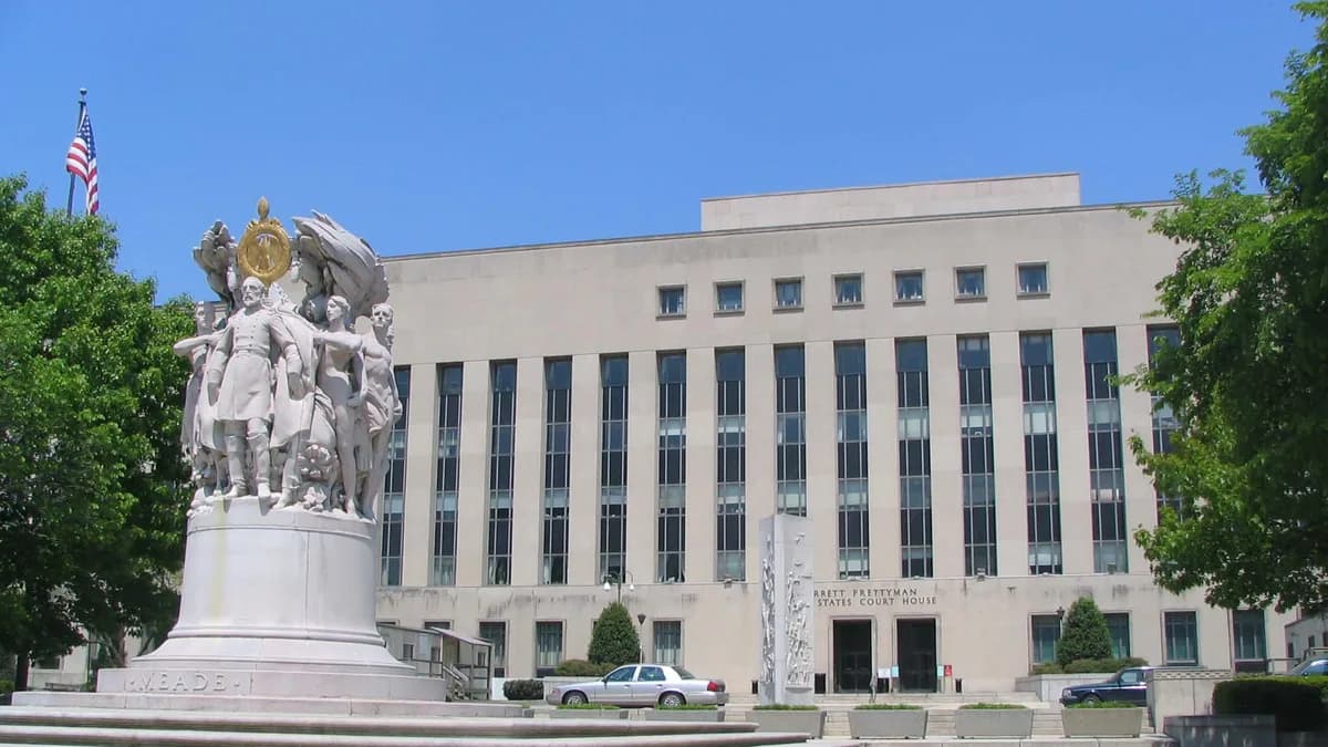 A large stone courthouse with tall vertical windows behind a white marble memorial statue under a clear blue sky. | No machine-readable author provided. Phyzome assumed (based on copyright claims)./Wikimedia Commons (CC BY-SA 3.0)