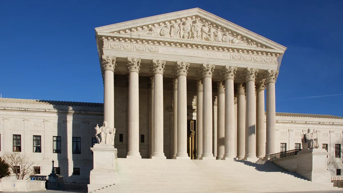 Front of the US Supreme Court building with tall marble columns, a carved pediment, wide steps and two seated statues under a clear blue sky. | Jarek Tuszyński/Wikimedia Commons (CC BY-SA 3.0)
